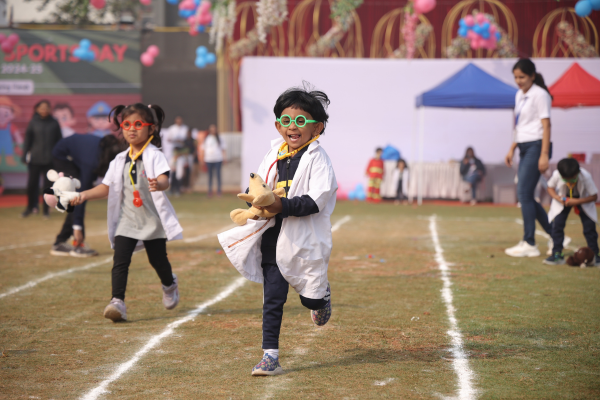 Preschoolers in PCMC, participating in a themed race wearing white lab coats and stethoscopes during Sports Day.